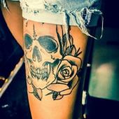 tatuaż czaszka z różą na udzie