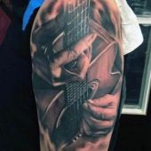 tatuaże muzyczne gitara na ramieniu