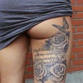 tatuaż róże z sentencją na udzie