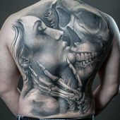 woman kissing skull tattoo
