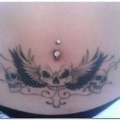 skull tattoo and wings on stomach