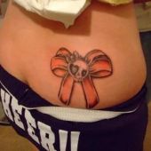 lower back tattoos skull and bow