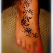 kwiaty i motyl na stopie tatuaż